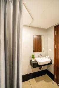 a bathroom with a sink and a shower curtain at Vari Homestay Đội Cấn in Hanoi