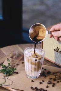 a person is pouring chocolate into a drink at Lijiang Old Town Noiseless Zen Courtyard in Lijiang +140 photos