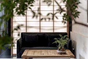 a black couch sitting next to a wooden coffee table at Silent NOISELESS Homestay in Lijiang