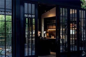 a room with glass doors and a bar with wine glasses at Silent NOISELESS Homestay in Lijiang