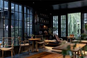 a room with tables and chairs and large windows at Lijiang Old Town Noiseless Zen Courtyard in Lijiang