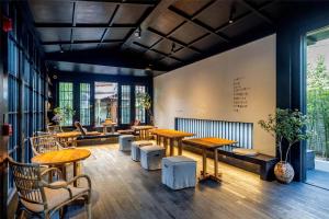 a restaurant with wooden tables and chairs and a couch at Lijiang Old Town Noiseless Zen Courtyard in Lijiang