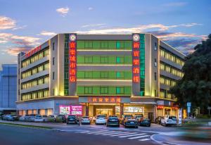 深セン市にあるMotri莫里宝乐城市酒店の駐車場に車が駐車されている建物