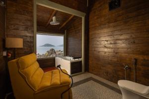 a room with a yellow chair and a window at The Ark Comforts in Palolem