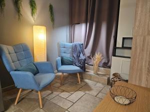 a living room with two blue chairs and a table at Vue panoramique lac d'Annecy, Maison chaleureuse avec cheminée, Parking privé, Cadre exceptionnel in Saint-Jorioz