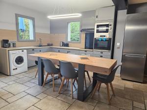 a large kitchen with a wooden table and chairs at Vue panoramique lac d'Annecy, Maison chaleureuse avec cheminée, Parking privé, Cadre exceptionnel in Saint-Jorioz