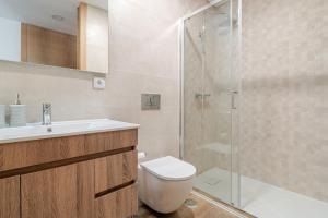 ein Badezimmer mit Dusche, Toilette und Waschbecken in der Unterkunft Serração House - Gerês in Rio Caldo + 32 Fotos