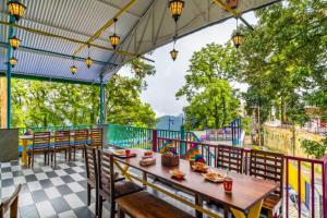 a restaurant with a table and chairs on a patio at goSTOPS Mussoorie Clock Tower in Mussoorie