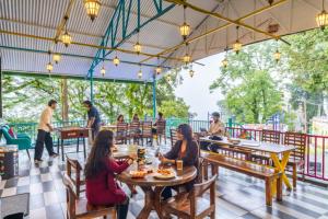 a group of people sitting at tables in a restaurant at goSTOPS Mussoorie Clock Tower in Mussoorie