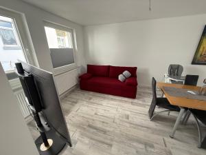 a living room with a red couch and a table at FEWO FFM str in Kassel