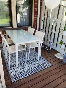 a glass table and chairs on a porch at Luxury 1br apartment in Liminka
