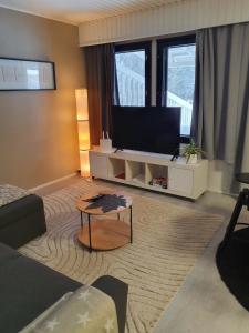 a living room with a tv and a coffee table at Luxury 1br apartment in Liminka