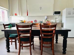een keuken met een tafel met stoelen en een koelkast bij Leura Hotel in Camperdown