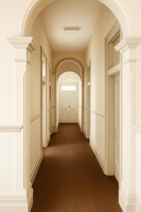 een lege gang van een gebouw met een witte deur bij Leura Hotel in Camperdown