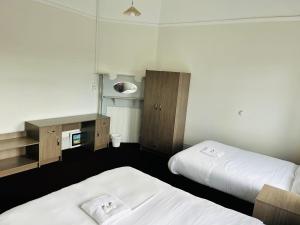 een hotelkamer met twee bedden en een spiegel bij Leura Hotel in Camperdown
