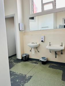 een badkamer met 2 wastafels en een raam bij Leura Hotel in Camperdown