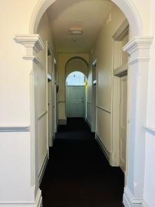 een lege hal met een groene deur in een gebouw bij Leura Hotel in Camperdown