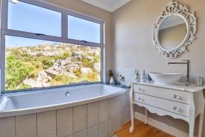 una bañera en un baño con ventana en Tranquility Heights, en Pringle Bay