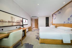 深セン市にあるMotri莫里宝乐城市酒店のベッド2台と机があるホテルの部屋