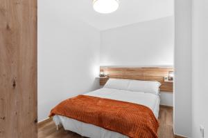 a bedroom with a white bed with an orange blanket at Casa Los Naranjos in Marbella