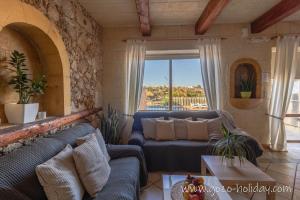 a living room with a couch and a table at Hibiscus in Xagħra