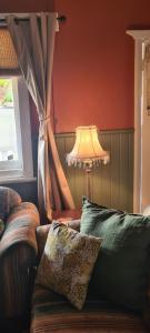 a living room with a couch and a lamp at May Queen Forest Cottage Manjimup in Deeside