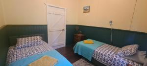 a bedroom with two beds and an open door at The May Queen - Footsteps in the Forest in Balbarrup