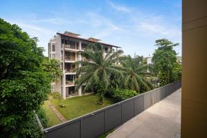 a balcony view of a building with palm trees at Laguna Beachside Residences Building 2 by Banyan Living in Bang Tao Beach