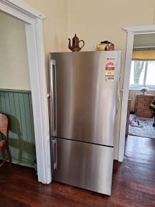 a stainless steel refrigerator sitting in a kitchen at The May Queen - Footsteps in the Forest in Balbarrup