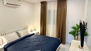 a bedroom with a blue bed and a window at Cozy Garden Apartment Butterfly Karon beach in Ban Karon +10 photos