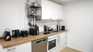 a kitchen with white cabinets and a wooden counter top at DANESSI-Business-Apartment, nahe Industriegebiet und Koblenz, WLAN, Smart TV Boxspringbett mit Waipu, Vollausgestattete Küche uvm in Mülheim-Kärlich