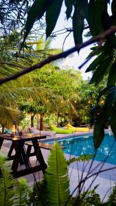 una mesa de madera junto a una piscina en Richards Cabanas, en Tissamaharama