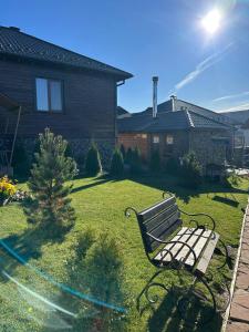 a park bench sitting in the yard of a house at Five House in Skhidnitsa