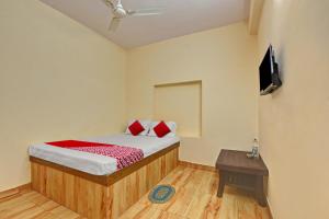a small bedroom with a bed and a table at Hotel O The Harsa Inn in Sānkchi