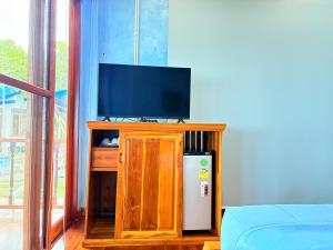 a living room with a television and a refrigerator at พฤกษาวารี รีสอร์ท 