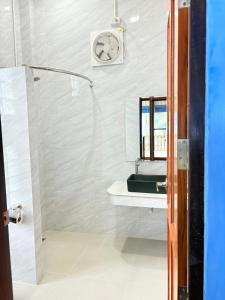 a bathroom with a shower and a clock on the wall at พฤกษาวารี รีสอร์ท  +27 photos