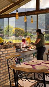 eine Frau steht an einer Theke in einer Küche in der Unterkunft Pousada Rancho na Serra in Espera Feliz
