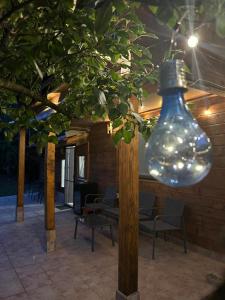 a large glass bulb hanging from a tree with chairs at AMA Bliss in Avrig