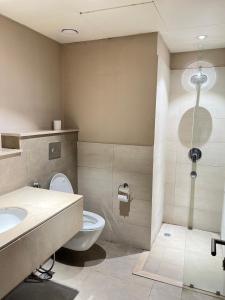 a bathroom with a toilet and a sink and a shower at 1 Constitution Avenue By Goldfinch in Islamabad