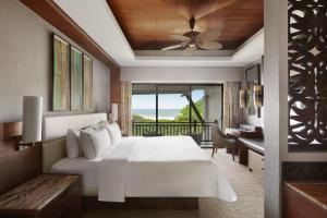 Un dormitorio con una cama con ventilador de techo y un balcón. en Shangri-La Rasa Ria, Kota Kinabalu, en Kota Kinabalu 166 fotos más