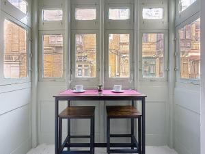 a table with two cups on it in a room with windows at Modern Studio Apartment1 next to Valletta in Il-Furjana +8 photos