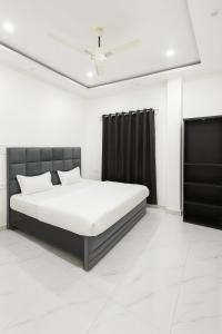 Dormitorio blanco con cama y cortinas negras en SAIR Hostel, Varanasi - 100m from Assi Ghat, en Varanasi