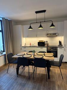 a kitchen with a table and chairs in a room at Charmant logement au cœur de la nature ardennaise in Habay-la-Neuve