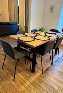 a wooden table with chairs around it in a room at Charmant logement au cœur de la nature ardennaise in Habay-la-Neuve +4 photos