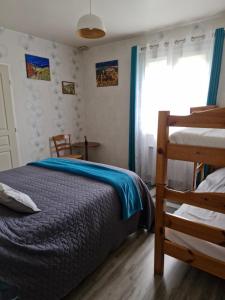 un dormitorio con una cama y dos literas en Chambre d hotes dans maison au calme et bien située pour visiter de nombreux sites, en Saint-Pantaléon-de-Larche