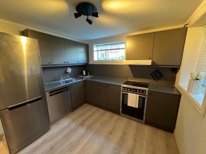 a kitchen with stainless steel appliances and wooden floors at Cozy and centrally located apartment in Tromsø +3 photos