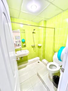 a bathroom with a shower and a toilet and a sink at ABCYQ Hotel in Bangkok