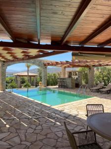 a swimming pool with a table and chairs at Villa with private pool and stunning sea view in Galaxidi