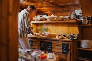 Een man die eten klaarmaakt aan een bar in een restaurant. bij Hotel Oberland in Triesenberg