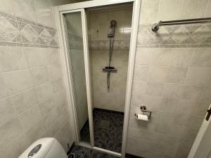 a bathroom with a shower and a toilet in it at Cozy and centrally located apartment in Tromsø